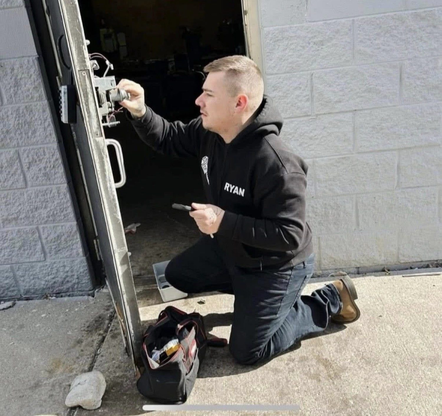 Ryan Taylor working on a commercial door for City Locksmith Taylor